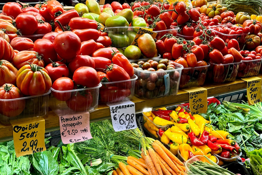 Pomodori, peperoni e carote su un banco di frutta e verdura del mercato di Bologna