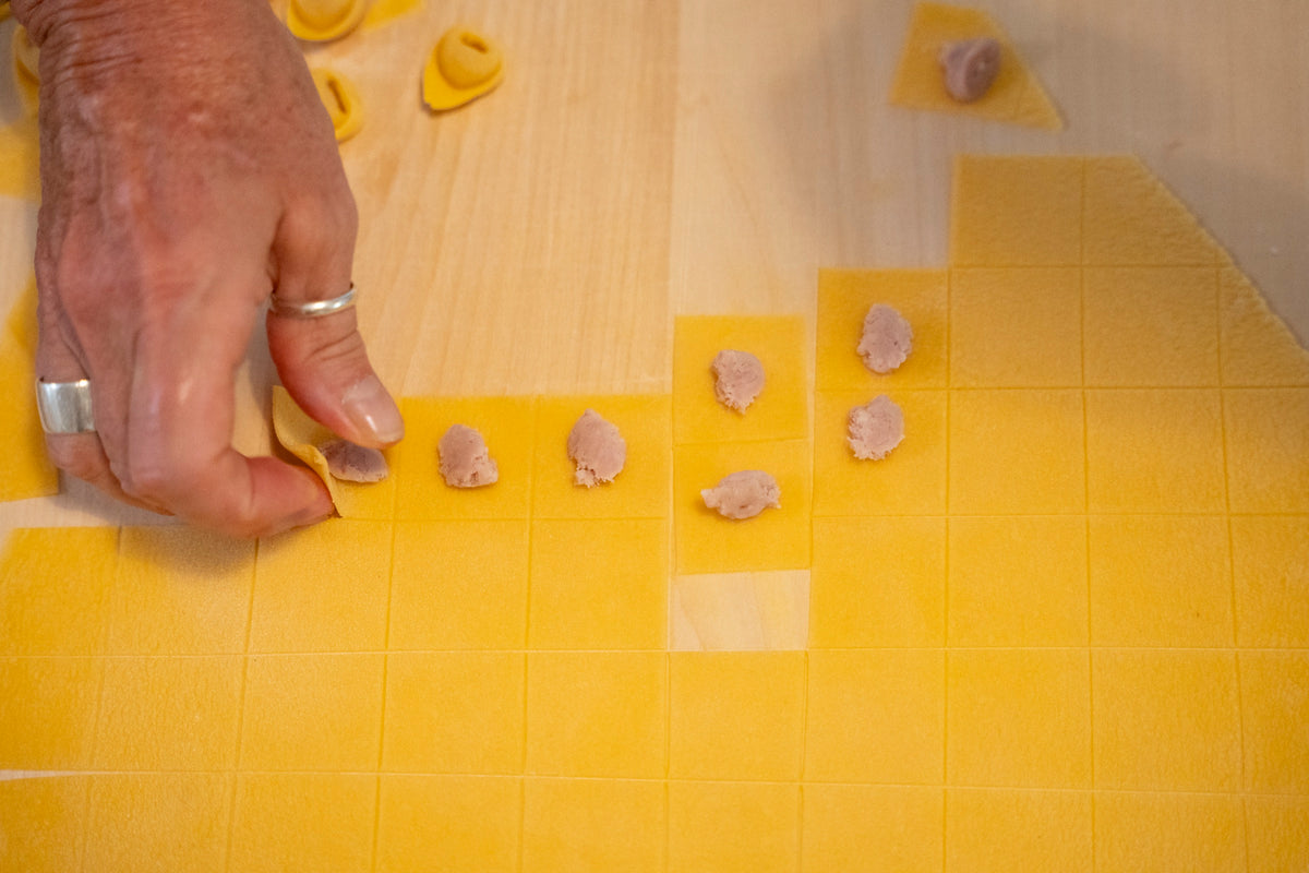 Il ripieno appoggiato sulla sfoglia, prima di chiudere i tortellini a mano