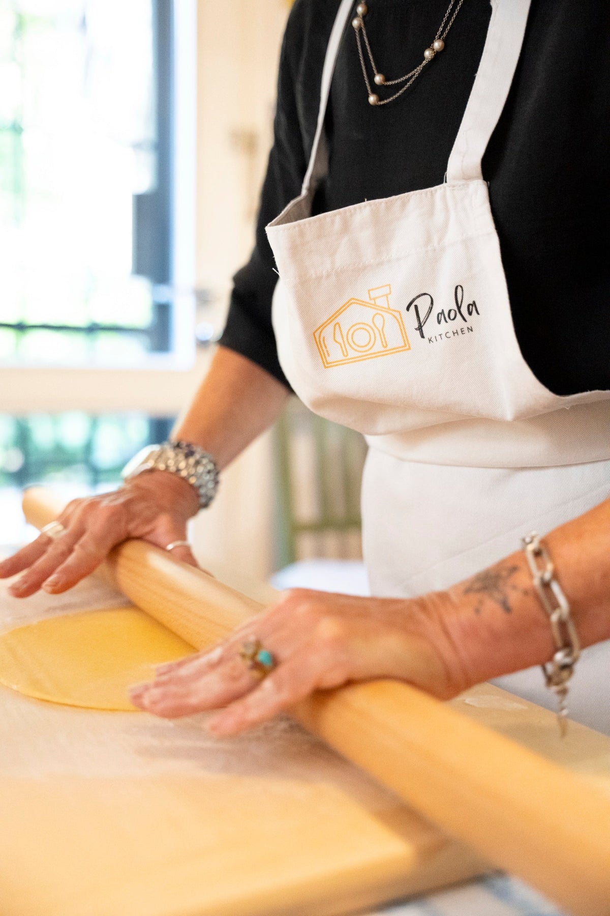 Paola tira la sfoglia a mano col matterello, nella sua cucina di casa a Bologna